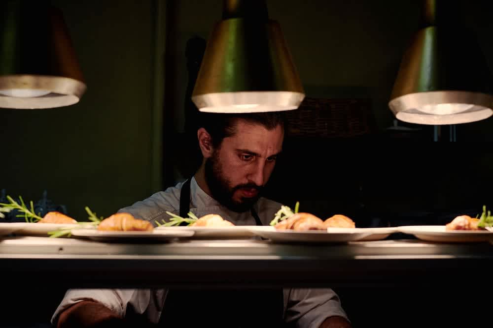 A chef looking over the pass at Rina's in Armadale.
